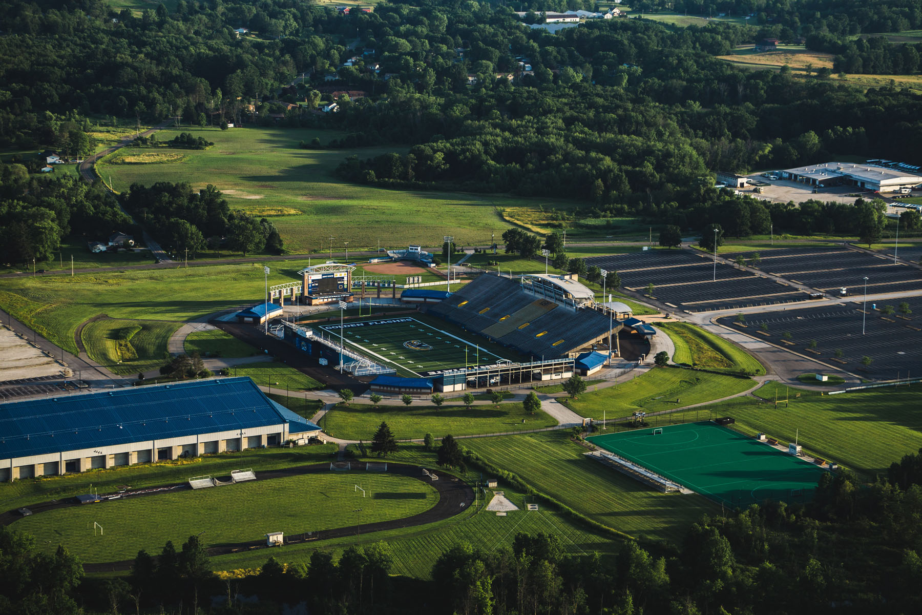 A college athletics complex shows the football stadium, the field house and the turf field.